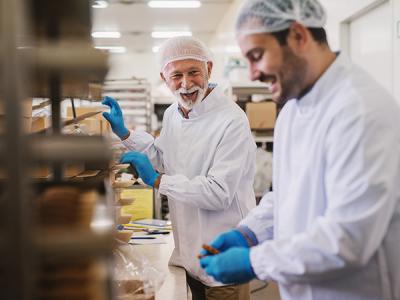 Two men in food processing facility packing food