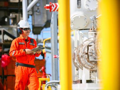 Worker inspecting oil and gas facility