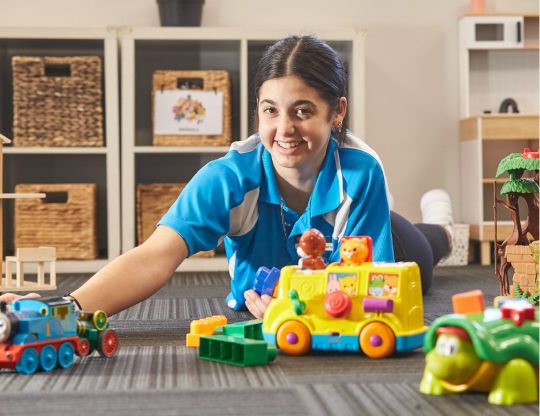 Female Early childhood worker surrounded by toys.