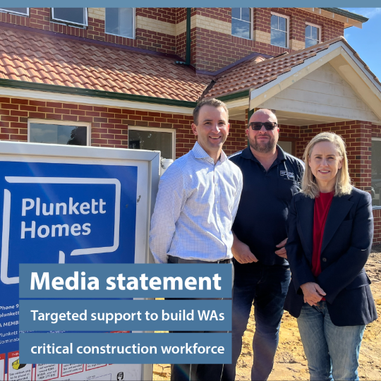 Minister McGuirk stood with construction management outside a newly built home.